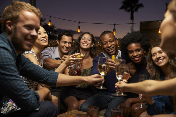 Group Of Friends Enjoying Night Out At Rooftop Bar consumers