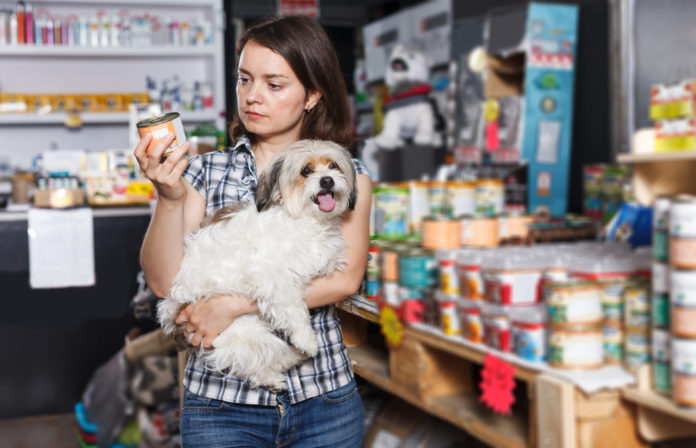 Young,Serious,Woman,With,Dog,Buying,Preserves,For,Dogs,In visitors